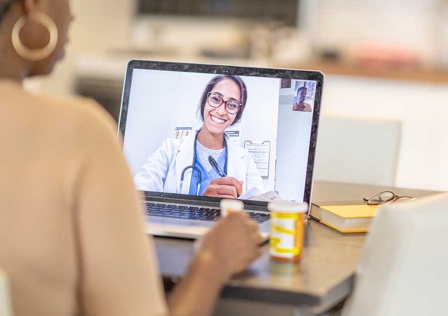 members-vh A woman having a video call with a doctor on a laptop
