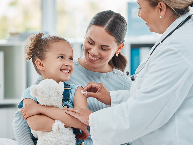 Mother and daughter at doctors office after little girl receives a shot.