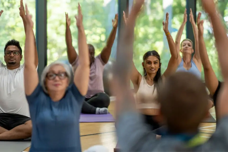 Diverse group of people doing seated yoga poses