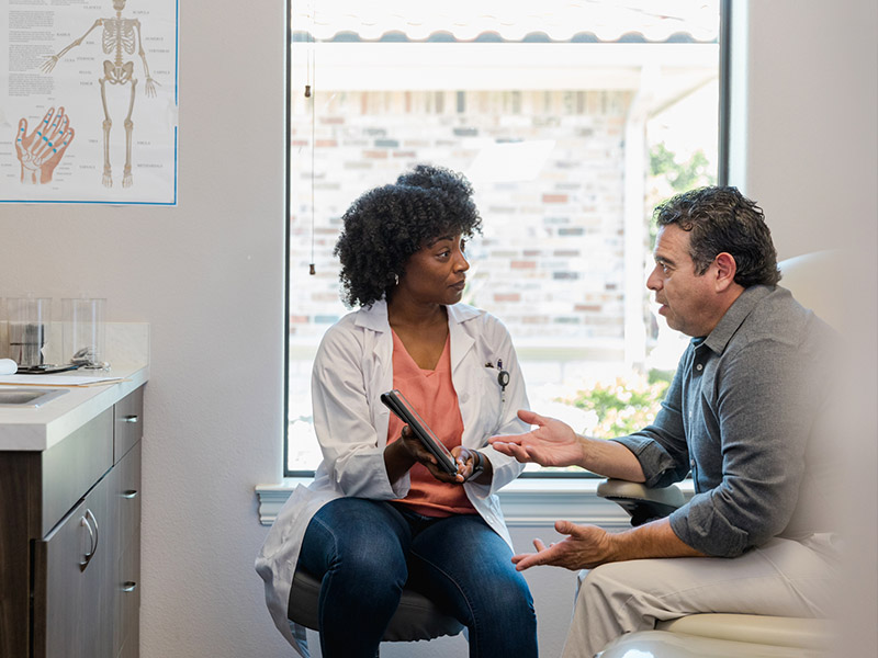 mens Man talking to a doctor while at a doctor visit