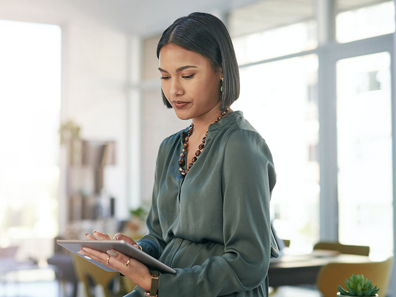 Woman standing in a room using a tablet