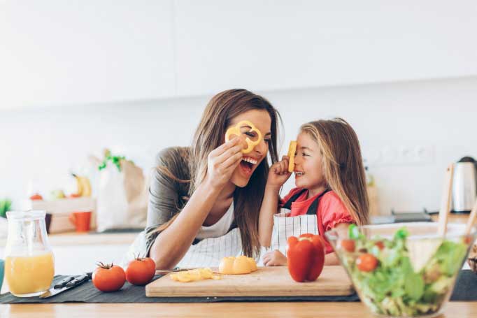 A woman and while cooking a meal in a kitchen