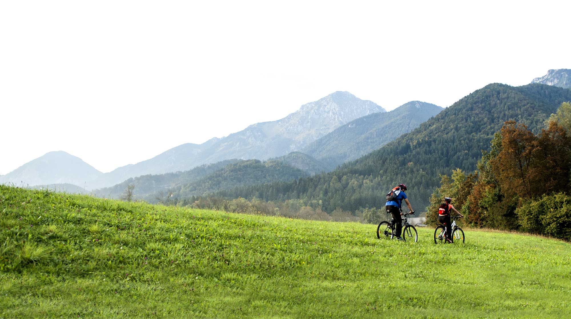 bnr-blue365 Two people riding a bike through a mountain valley