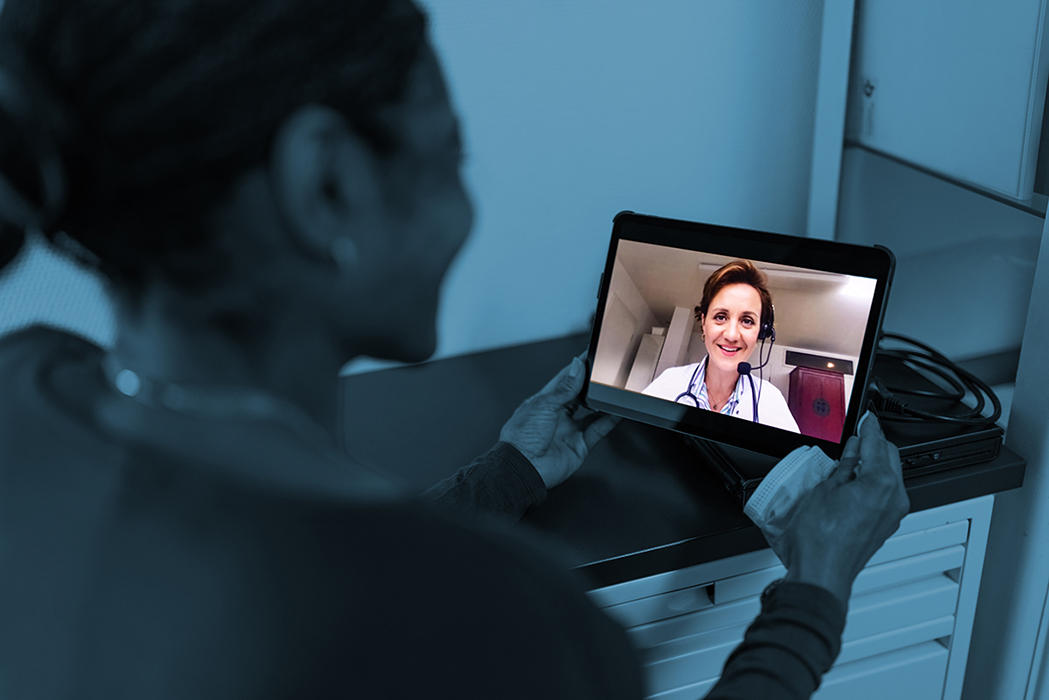 bnr-virtual-health Woman holding iPad with a doctor on it.